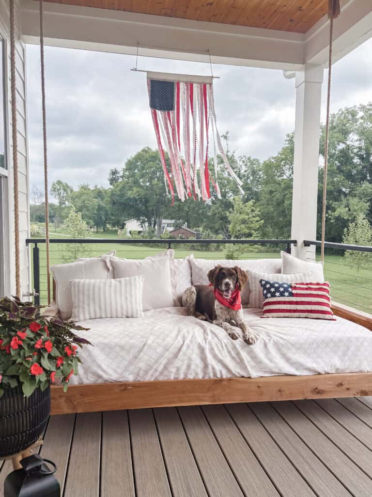 dog sitting on patriotic front porch
